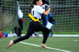 girl running with rugby ball