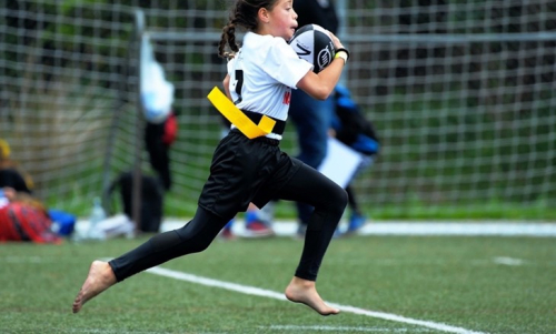 girl running with rugby ball